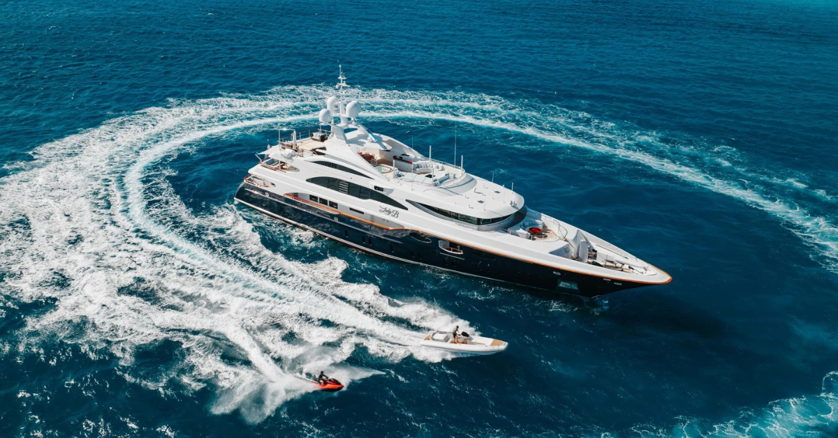 Luxury motor yacht cruising the turquoise waters of Mykonos with Cyclades islands in the background